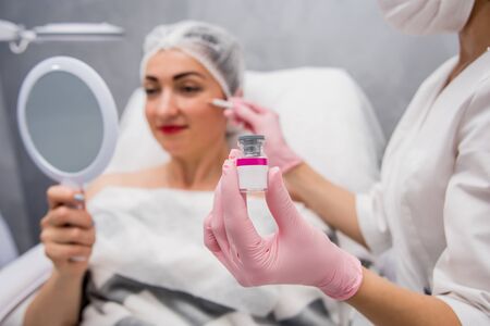 The doctor cosmetologist makes the facial injections procedure.の写真素材