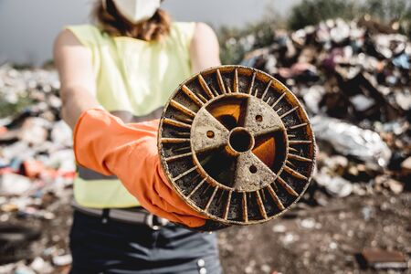 Woman volunteer helps clean the field of nuclear waste and plastic garbageの写真素材