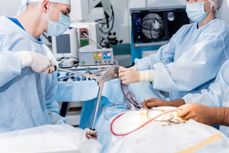Spinal surgery. Group of surgeons in operating room with surgery equipment.の写真素材
