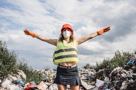 Woman volunteer helps clean the field of plastic garbage.の写真素材