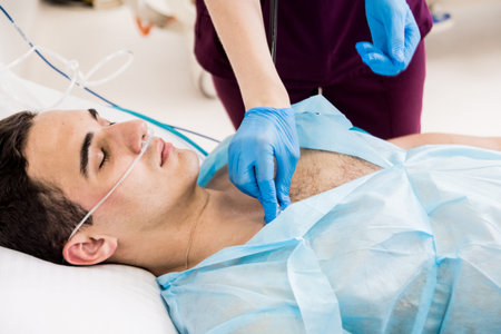 Doctors give resuscitation to a male patient in the emergency room. Cardiac massage. Defibrillation