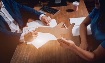 Man signing a life insurance policy, the agent is holding the wooden planeの写真素材