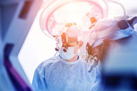 Spinal surgery. Group of surgeons in operating room with surgery equipment.の写真素材