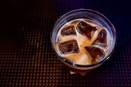 Alcoholic cocktail with ice at wooden bar counter. Restaurant.の写真素材