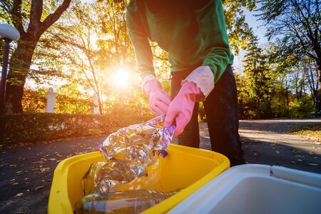 Volunteer girl sorts garbage in the street of the park. Concept of recycling. Zero waste concept. Nature backgroundの写真素材