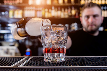 Bartender is making cocktail at bar counter. Fresh cocktails. Barman at work.