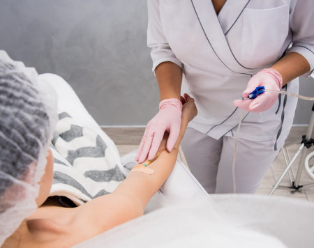 The doctor cosmetologist makes cosmetology dropper procedure. Infusion. Young woman in a beauty...