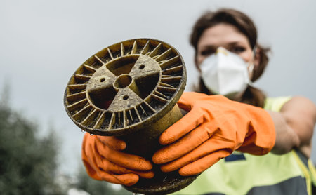 Woman volunteer helps clean the field of nuclear waste and plastic garbage.の写真素材