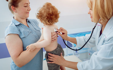Friendly doctor pediatrician with patient child at clinic