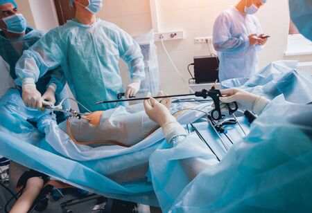 Process of gynecological surgery operation using laparoscopic equipment. Group of surgeons in operating room with surgery equipment. Backgroundの写真素材