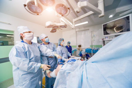 Arthroscope surgery. Orthopedic surgeons in teamwork in the operating room with modern arthroscopic...