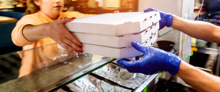 Tasty pizza in the delivery boxes. Kitchen.