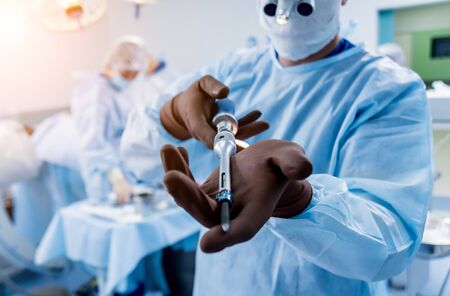 Spinal surgery. Surgeon show polyaxial screw in operating roomの写真素材