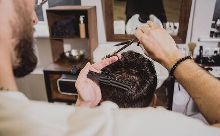 Young man with trendy haircut at barber shop.の写真素材