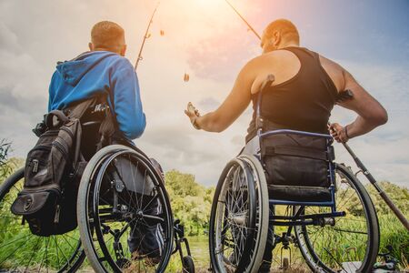 Handicapped men fishing at a lake. Wheelchair. Camping.の写真素材