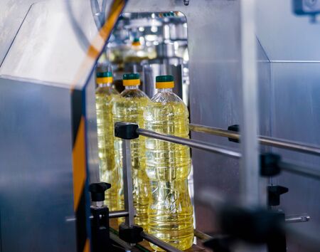 Bottling line of sunflower oil in bottles. Vegetable oil production plant. High technology. Industrial backgroundの写真素材