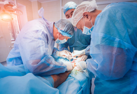 Process of trauma surgery operation. Group of surgeons in operating room