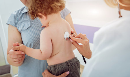 Friendly doctor pediatrician with patient child at clinic
