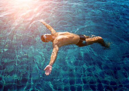 Young athletic man swimming in the swimming pool. Active sportの写真素材