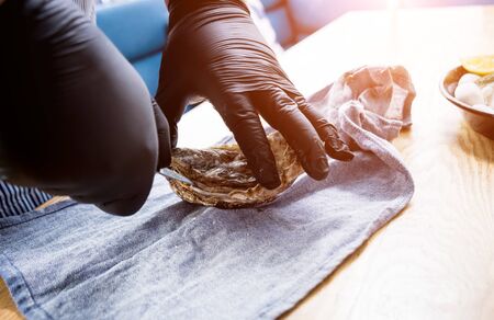 Chef opens a fresh oyster. Dish with open oysters. Restaurant.の写真素材