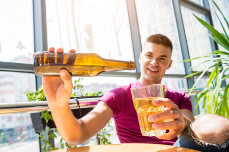 Young man in the pub. Drinking beer, eating pizza.の写真素材