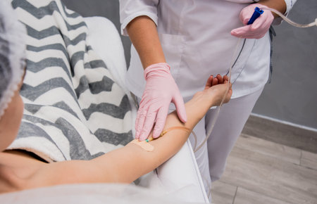 The doctor cosmetologist makes cosmetology dropper procedure. Infusion. Young woman in a beauty...