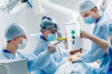Spinal surgery. Group of surgeons in operating room with surgery equipment. Laminectomy. Modern medical backgroundの写真素材