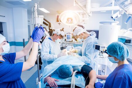 Spinal surgery. Group of surgeons in operating room with surgery equipment. Laminectomy. Modern medical backgroundの写真素材