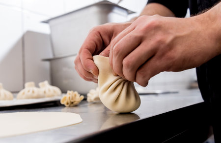 Chef coocking georgian khinkali or japanese wonton. Traditional meal of dough and meat. National...