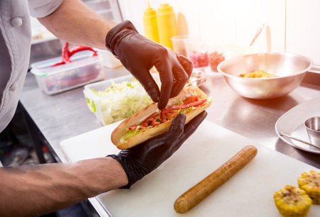 The chef cooking hot dog on a grill. Restaurant.の写真素材