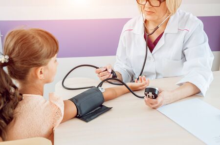 Doctor measuring blood pressure of a little girl. Diagnostic, healthcare, medical serviceの写真素材