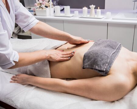 Beautiful young woman enjoying massage in spa salon. Cosmetology conceptの写真素材