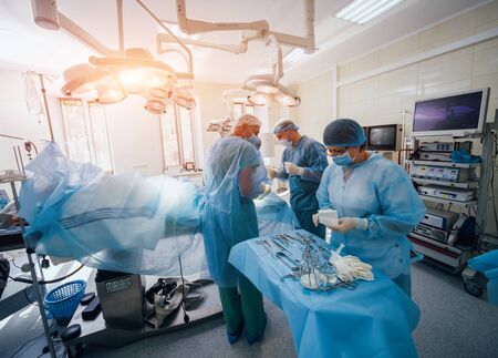 Process of trauma surgery operation. Group of surgeons in operating room with surgery equipment. Medical backgroundの写真素材