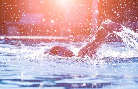Young athletic man swimming in the swimming pool. Active sportの写真素材