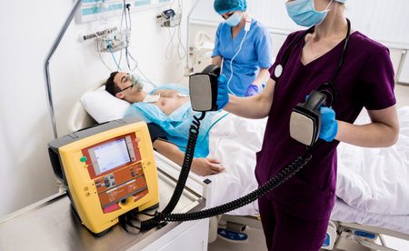 Doctors give resuscitation to a male patient in the emergency room. Cardiac massage. Defibrillation