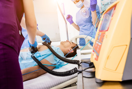 Doctors give resuscitation to a male patient in the emergency room. Cardiac massage. Defibrillation
