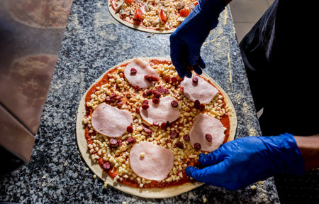 The process of making pizza. Hands of chef baker making pizza at cafe kitchen