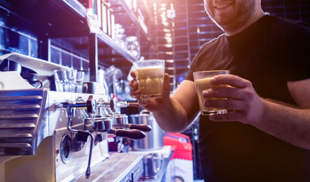 The bartender makes the coffee, cappuccino, cocoa, drink at the bar.