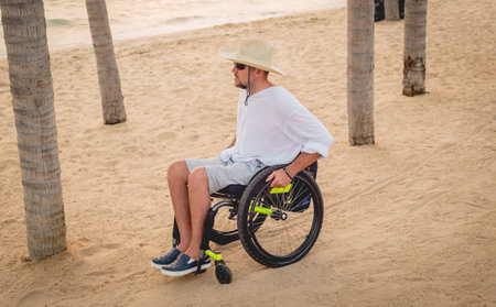 Disabled man in a wheelchair on the beach.の写真素材