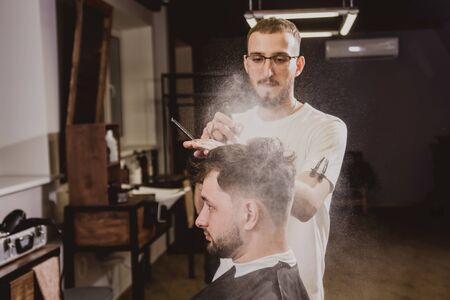 Young man with trendy haircut at barber shop.の写真素材