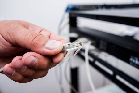 Technician connecting network cables to switches. Connecting cablesの写真素材