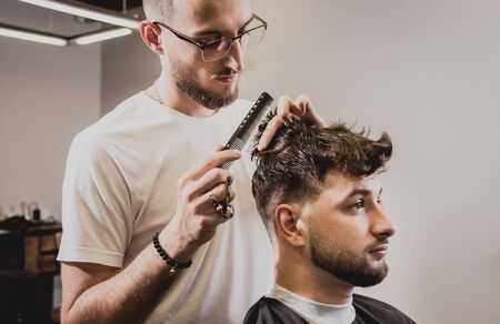 Young man with trendy haircut at barber shop.の写真素材