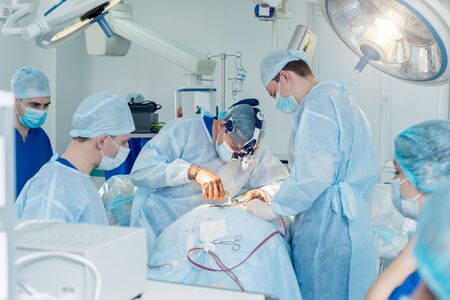 Spinal surgery. Group of surgeons in operating room with surgery equipment.の写真素材