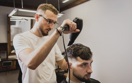 Young man with trendy haircut at barber shop.の写真素材