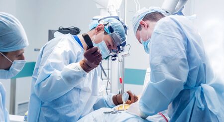 Spinal surgery. Group of surgeons in operating room with surgery equipment. Laminectomy. Modern medical backgroundの写真素材