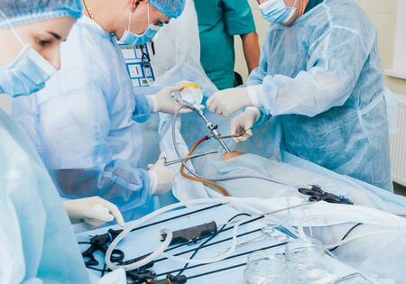Process of gynecological surgery operation using laparoscopic equipment. Group of surgeons in operating room with surgery equipment. Backgroundの写真素材