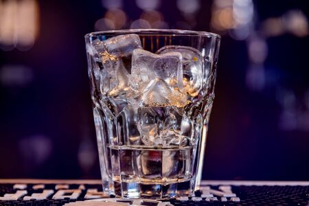 Alcoholic cocktail with ice at wooden bar counter. Restaurant.の写真素材
