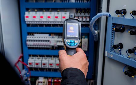 Technician use infrared thermal imaging camera to check temperature at fuse-box. Modern equipmentの写真素材