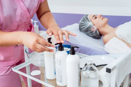 Facial cosmetic procedure in spa salon. The procedure for applying a mask to the face of a beautiful woman. Spa treatmentsの写真素材