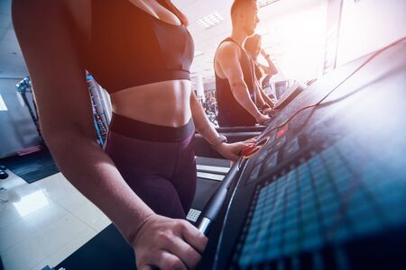 Young peoples training on treadmill at the gym. In fitness center.の写真素材